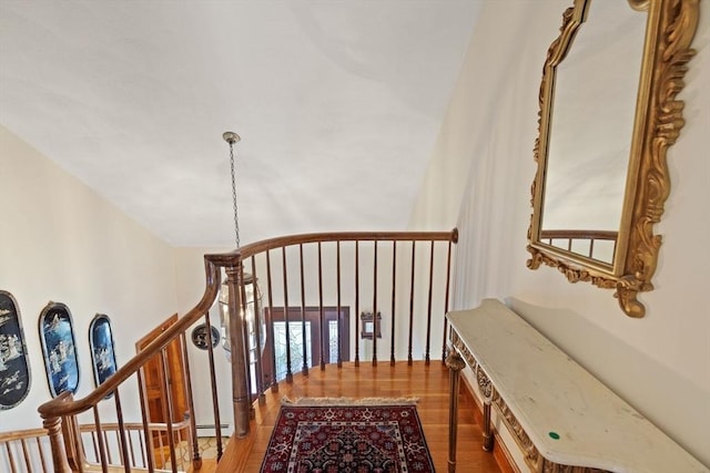 hall with a baseboard heating unit and wood finished floors