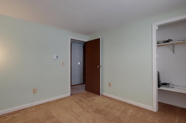 unfurnished bedroom with baseboards, a closet, and light colored carpet