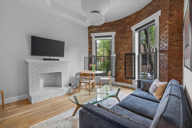 26 Concord Sq Unit 2, Boston, MA 02118 - living room with a fireplace, brick wall, baseboards, and wood finished floors