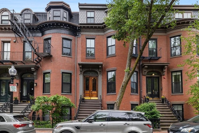 26 Concord Sq Unit 2, Boston, MA 02118 - view of front facade featuring mansard roof, french doors, stairs, and brick siding