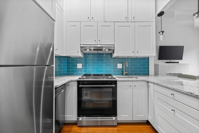 26 Concord Sq Unit 2, Boston, MA 02118 - kitchen with stainless steel appliances, a sink, under cabinet range hood, light stone countertops, and backsplash