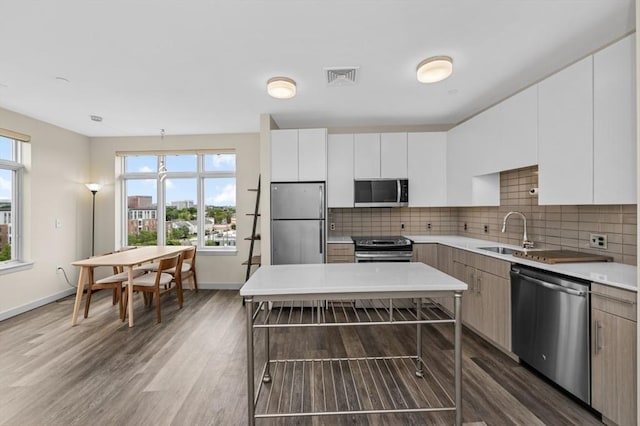 180 Telford St Unit 614, Boston, MA 02135 - kitchen with appliances with stainless steel finishes, a sink, wood finished floors, light countertops, and baseboards