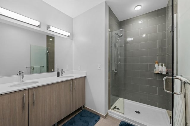 180 Telford St Unit 614, Boston, MA 02135 - bathroom featuring a stall shower, double vanity, tile patterned floors, and baseboards