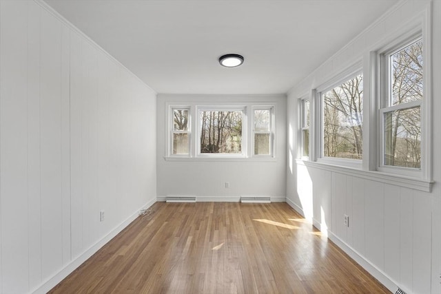 unfurnished sunroom with a baseboard heating unit