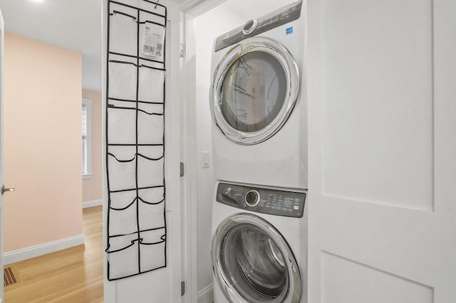 140 Main St Unit E, Amesbury, MA 01913 - laundry area featuring stacked washer / dryer, light wood finished floors, and baseboards