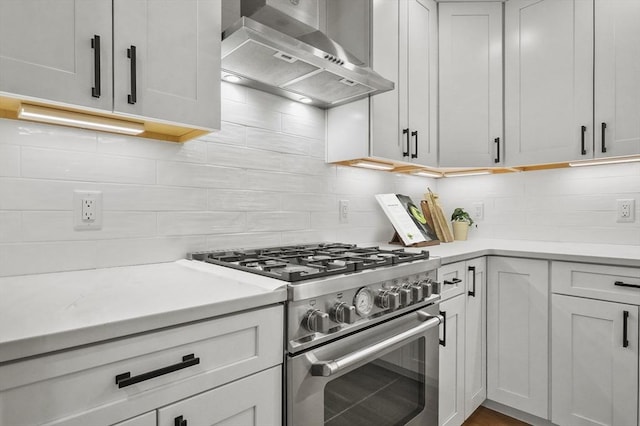 140 Main St Unit E, Amesbury, MA 01913 - kitchen featuring high end stainless steel range, exhaust hood, tasteful backsplash, and light countertops