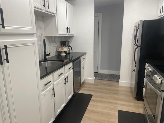 200 Manning St Unit 17C, Hudson, MA 01749 - kitchen featuring stainless steel electric range oven, white cabinets, a sink, dark stone counters, and baseboards