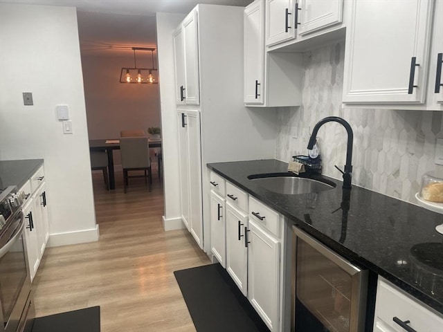 200 Manning St Unit 17C, Hudson, MA 01749 - kitchen with beverage cooler, stainless steel range, tasteful backsplash, a sink, and white cabinetry
