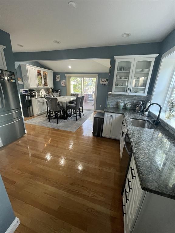 15 Bates Rd, Framingham, MA 01702 - kitchen with freestanding refrigerator, glass insert cabinets, a sink, white cabinetry, and dark stone counters