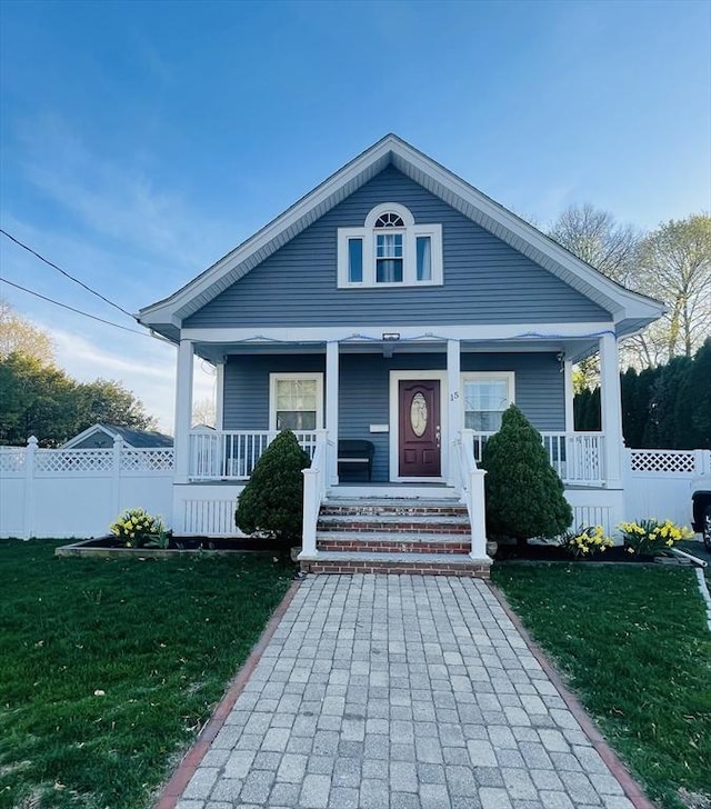 15 Bates Rd, Framingham, MA 01702 - bungalow-style home with covered porch, fence, and a front lawn