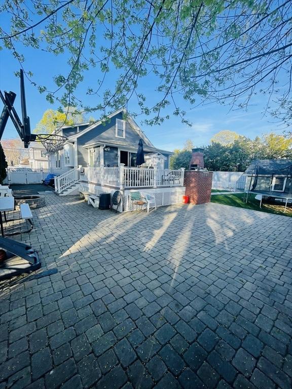 15 Bates Rd, Framingham, MA 01702 - exterior space with a trampoline, a patio area, a wooden deck, and fence