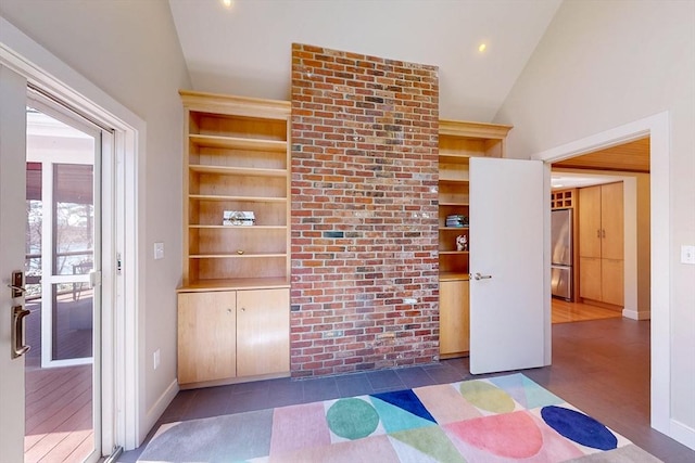 unfurnished room featuring built in features, vaulted ceiling, and baseboards