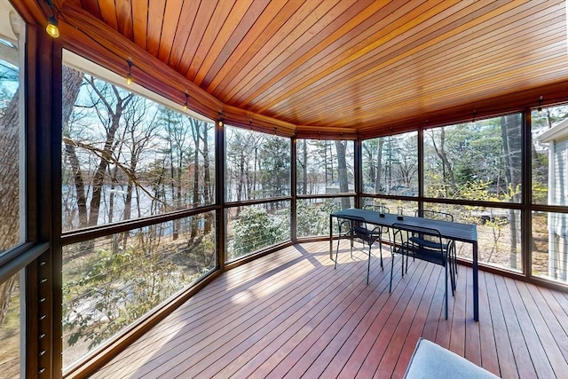 unfurnished sunroom with outdoor dining space and a water view
