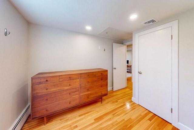 bedroom featuring a baseboard heating unit, recessed lighting, attic access, light wood-style floors, and visible vents