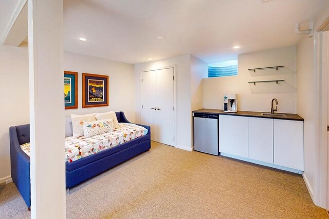 interior space with recessed lighting, a sink, wet bar, baseboards, and light colored carpet