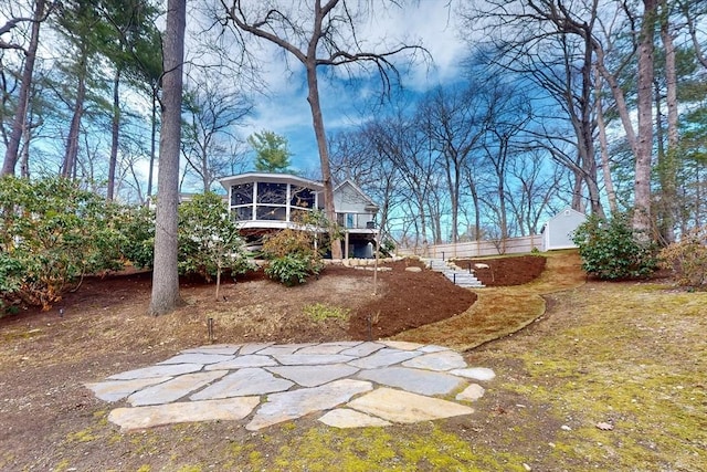 view of yard with a deck, a sunroom, and stairs