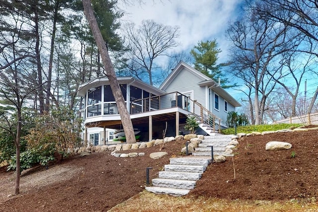 rear view of house featuring stairway and a sunroom