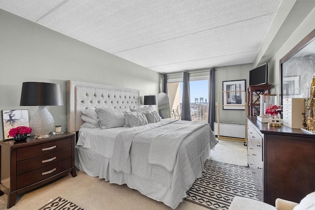 bedroom featuring light colored carpet, a textured ceiling, and access to outside