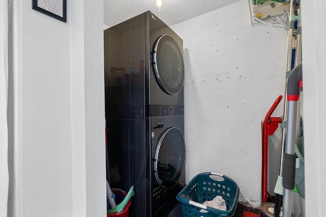 clothes washing area featuring laundry area and stacked washer / dryer