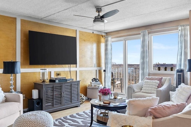 living room featuring a textured ceiling, a ceiling fan, and wood finished floors