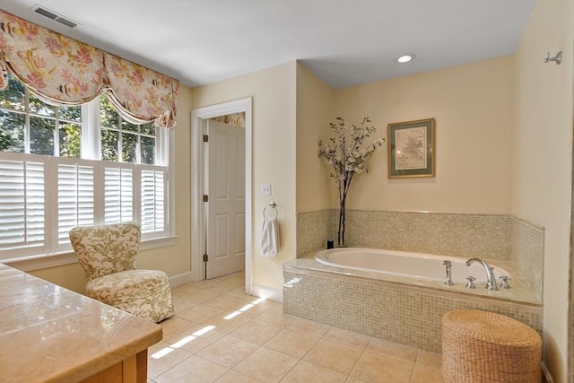 bathroom with tile patterned flooring, visible vents, baseboards, and a garden tub