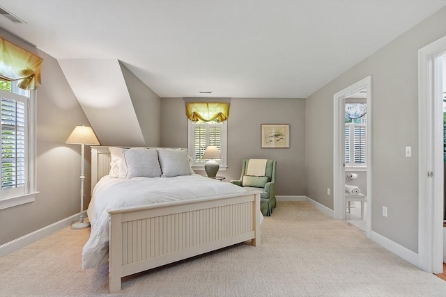 bedroom featuring multiple windows, baseboards, and light carpet