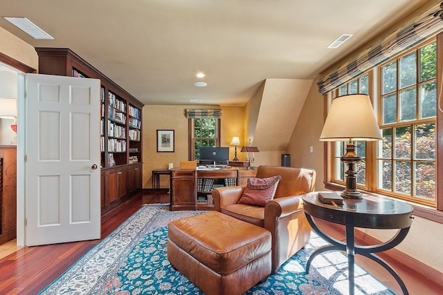 living area with visible vents and wood finished floors