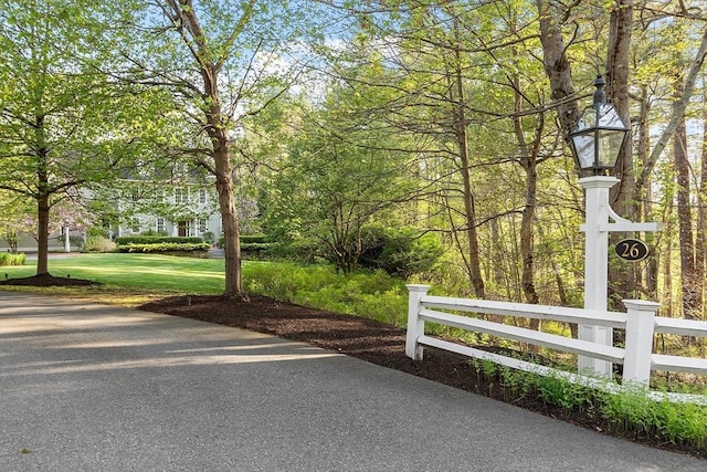 view of community featuring a yard and fence