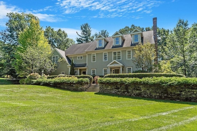 rear view of property with a lawn and a chimney