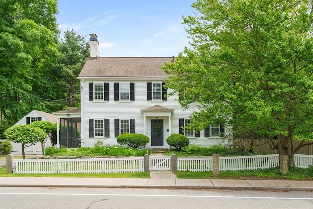 120 Court St, Dedham, MA 02026 - colonial inspired home featuring a chimney, a fenced front yard, and a sunroom