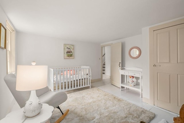 120 Court St, Dedham, MA 02026 - bedroom with tile patterned flooring, a crib, and baseboards