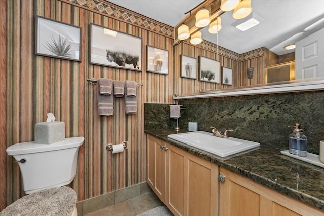 1100 Salem St Unit 103, Lynnfield, MA 01940 - bathroom with wallpapered walls, toilet, vanity, tasteful backsplash, and an enclosed shower