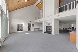 1100 Salem St Unit 103, Lynnfield, MA 01940 - unfurnished living room with high vaulted ceiling, carpet flooring, a fireplace, and wood ceiling