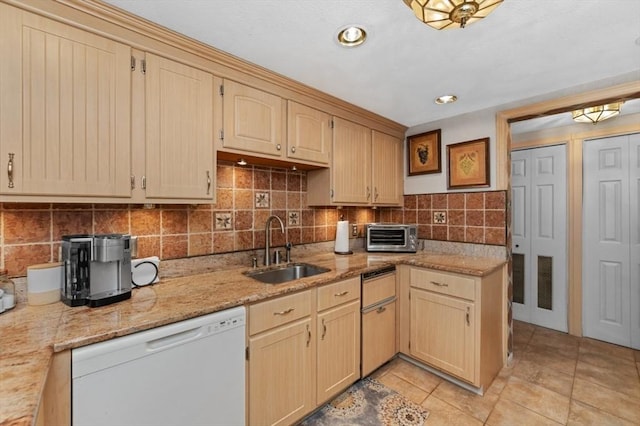 1100 Salem St Unit 103, Lynnfield, MA 01940 - kitchen with white dishwasher, a sink, light tile patterned floors, decorative backsplash, and light stone counters