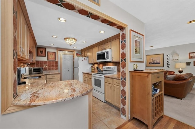 1100 Salem St Unit 103, Lynnfield, MA 01940 - kitchen with white appliances, recessed lighting, tasteful backsplash, a peninsula, and light stone countertops