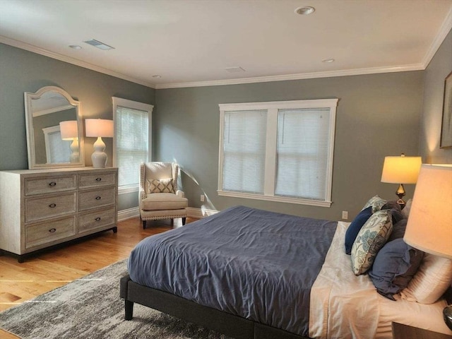 bedroom featuring crown molding and light hardwood / wood-style flooring