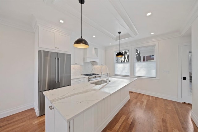 kitchen featuring appliances with stainless steel finishes, a kitchen island with sink, hanging light fixtures, custom range hood, and white cabinets