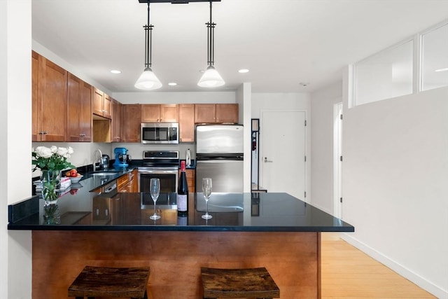 99 Chestnut Hill Ave Unit 212, Boston, MA 02135 - kitchen featuring appliances with stainless steel finishes, a sink, recessed lighting, a peninsula, and decorative light fixtures
