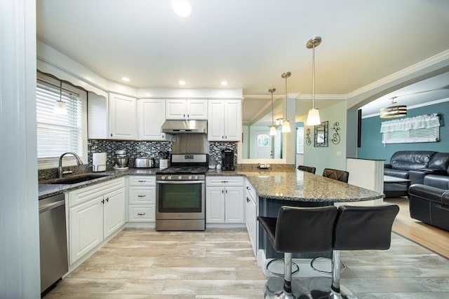 1286 Locust St, Fall River, MA 02723 - kitchen with stainless steel appliances, a sink, a peninsula, under cabinet range hood, and a breakfast bar area