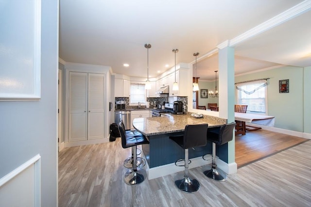 1286 Locust St, Fall River, MA 02723 - kitchen featuring stainless steel appliances, light wood-style floors, a peninsula, a breakfast bar, and plenty of natural light
