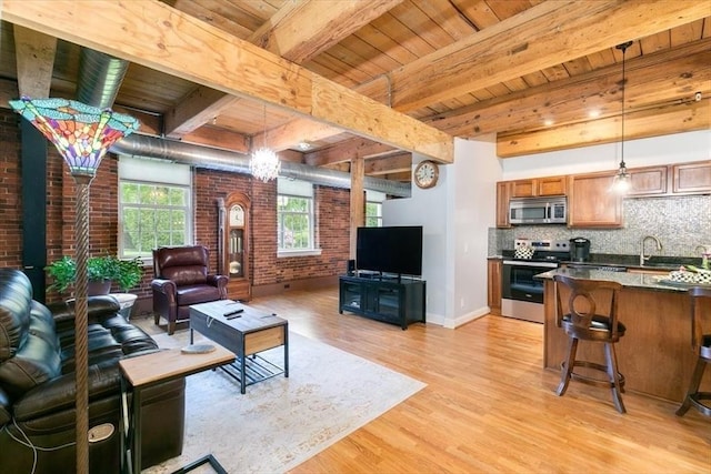 living room with wooden ceiling, light wood-style flooring, brick wall, beam ceiling, and baseboards
