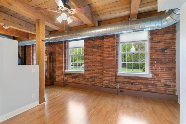 empty room featuring wood ceiling, wood finished floors, beam ceiling, baseboards, and brick wall