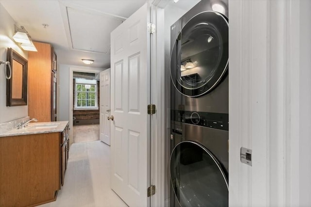 laundry room featuring stacked washer and clothes dryer and attic access