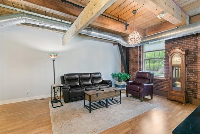 living area featuring wooden ceiling, wood finished floors, beamed ceiling, baseboards, and brick wall
