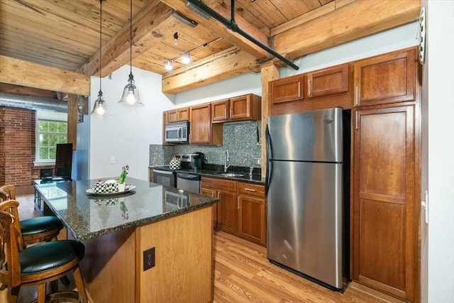 kitchen with appliances with stainless steel finishes, wooden ceiling, a sink, light wood-style flooring, and a breakfast bar