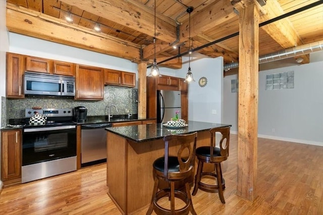 kitchen with appliances with stainless steel finishes, wooden ceiling, light wood-style flooring, brown cabinetry, and rail lighting