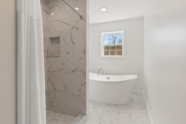 bathroom featuring a freestanding bath, a marble finish shower, baseboards, and marble finish floor