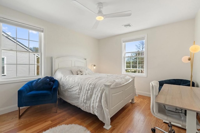 bedroom with baseboards, visible vents, ceiling fan, and light wood-type flooring