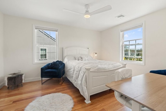 bedroom with visible vents, a ceiling fan, light wood-style floors, and baseboards