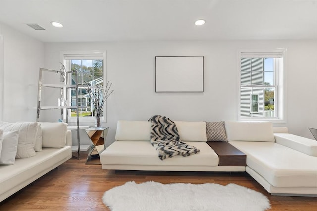 living area with visible vents, recessed lighting, and wood finished floors